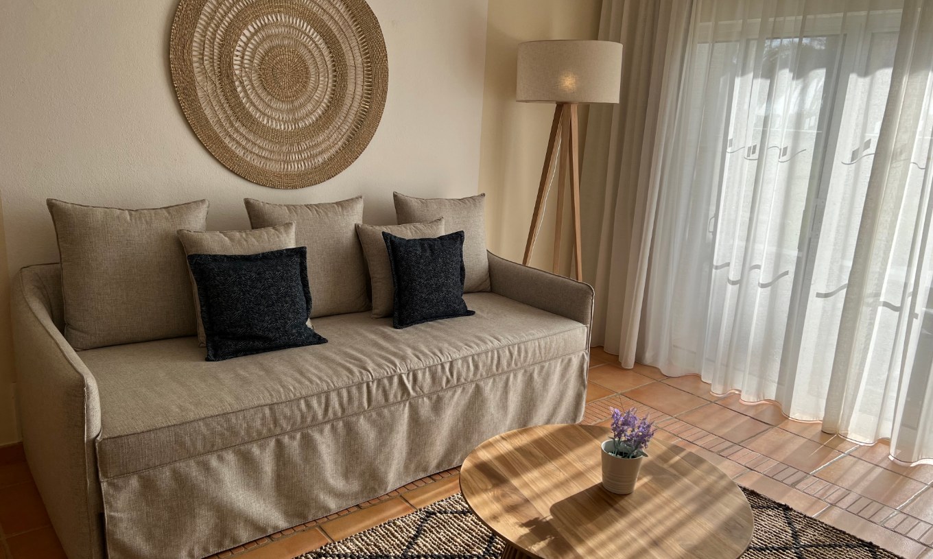 Appartement T2 Standard au Pestana Palm Gardens avec canapé beige, lampe sur pied et rideaux lumineux