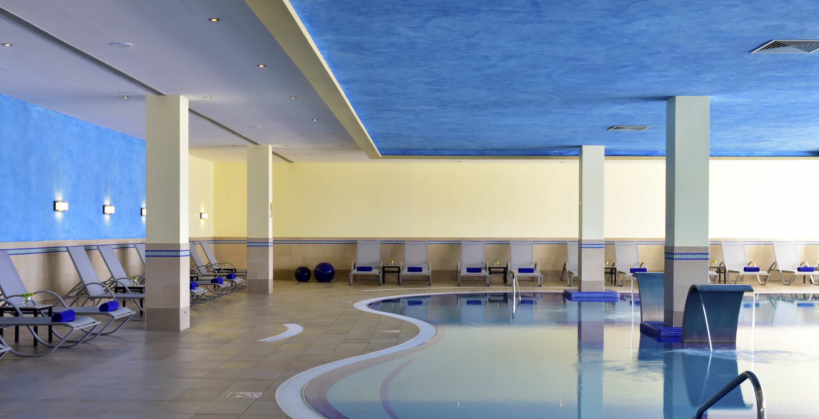 Piscine intérieure du Pestana Viking, murs bleus et jaunes, ambiance calme, avec plusieurs transats