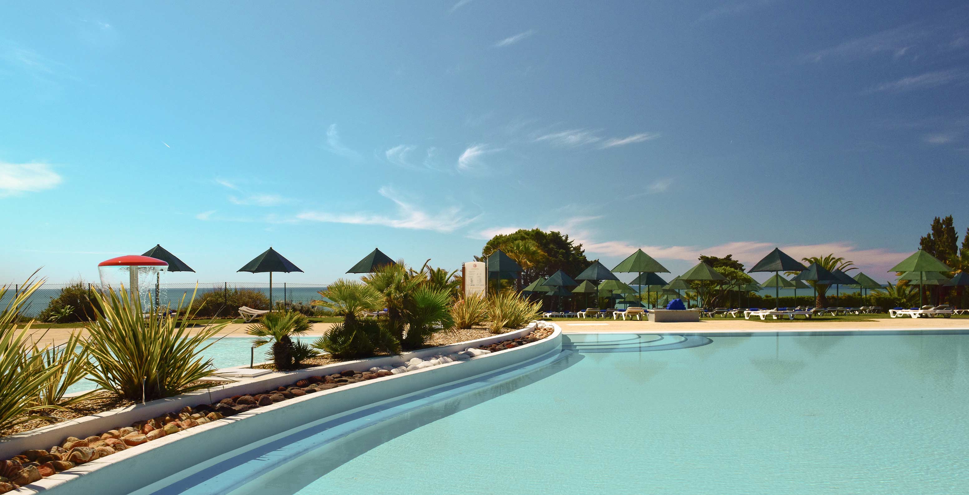 Piscine extérieure du Pestana Viking, entourée de végétation, avec transats et vue sur la mer