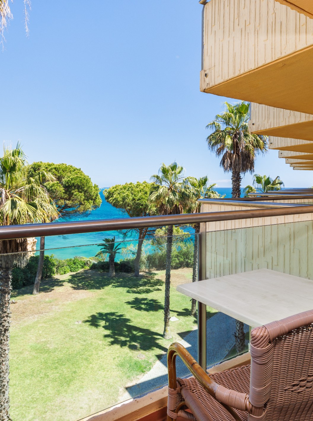 Chambre Deluxe Vue Latérale sur la Mer au Pestana Viking avec balcon meublé face aux palmiers et à la côte
