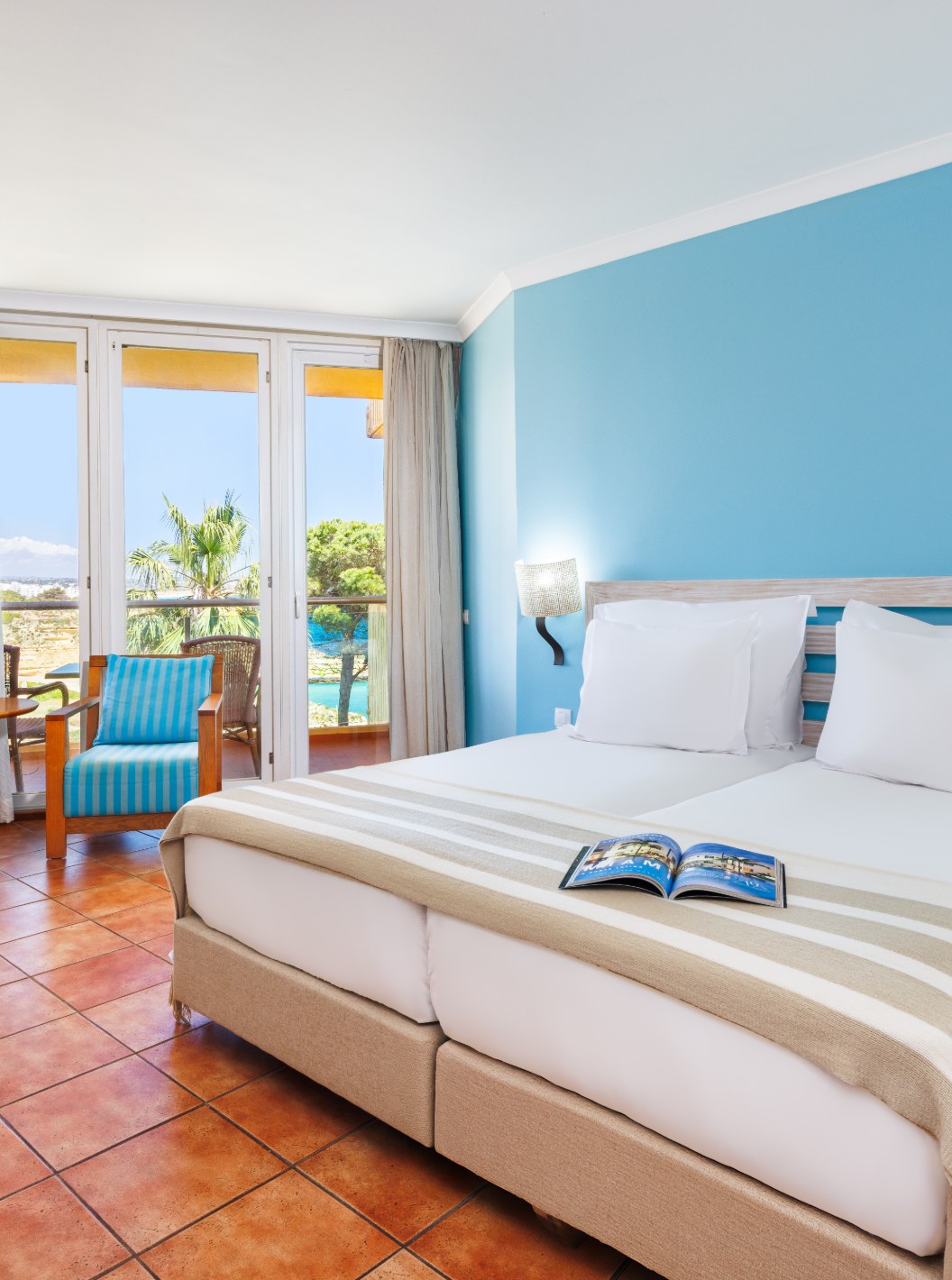 Deluxe Vue Latérale sur la Mer au Pestana Viking, chambre lumineuse avec balcon et fauteuils bleus