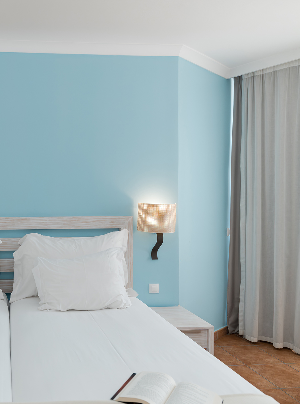 Le Deluxe Vue Mer du Pestana Viking a deux lits, deux tables de chevet et du papier peint bleu