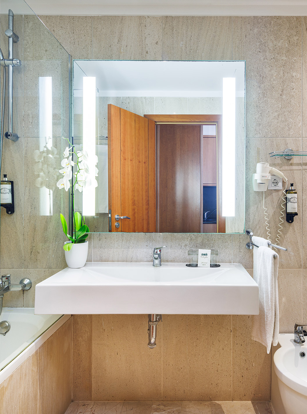 Chambre Deluxe du Pestana Viking avec salle de bain en marbre, grand miroir éclairé et douche vitrée