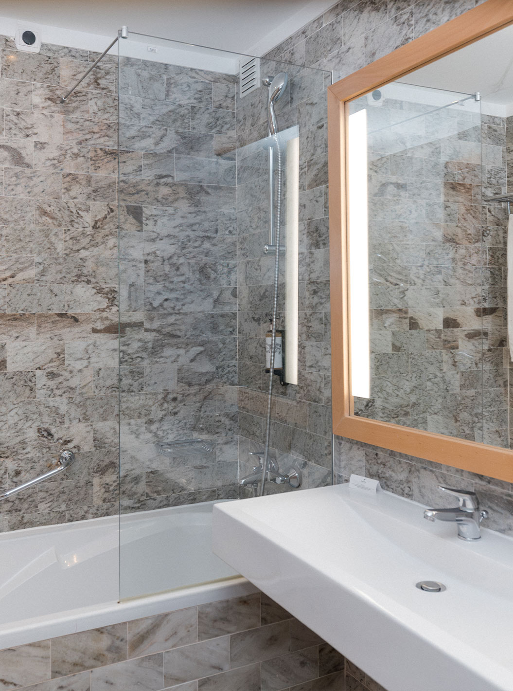 La Suite Supérieure Vue Mer du Pestana Viking a une salle de bain avec lavabo, grand miroir et baignoire avec douche