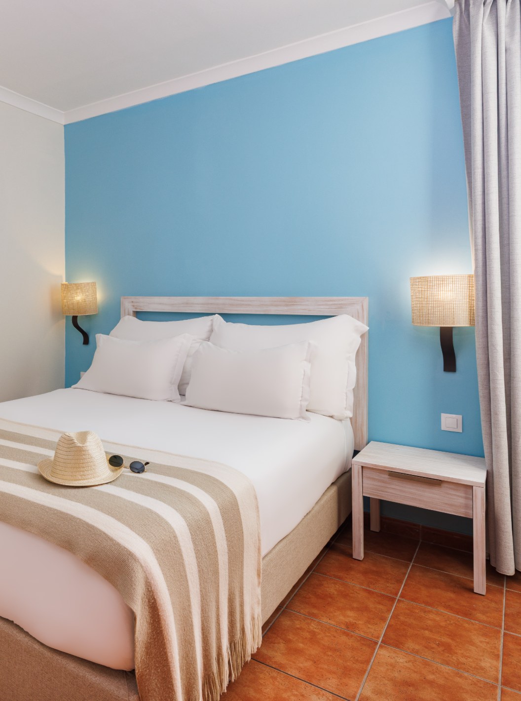 Suite T2 avec vue sur la mer du Pestana Viking avec lit double, mur bleu, table de chevet et bureau