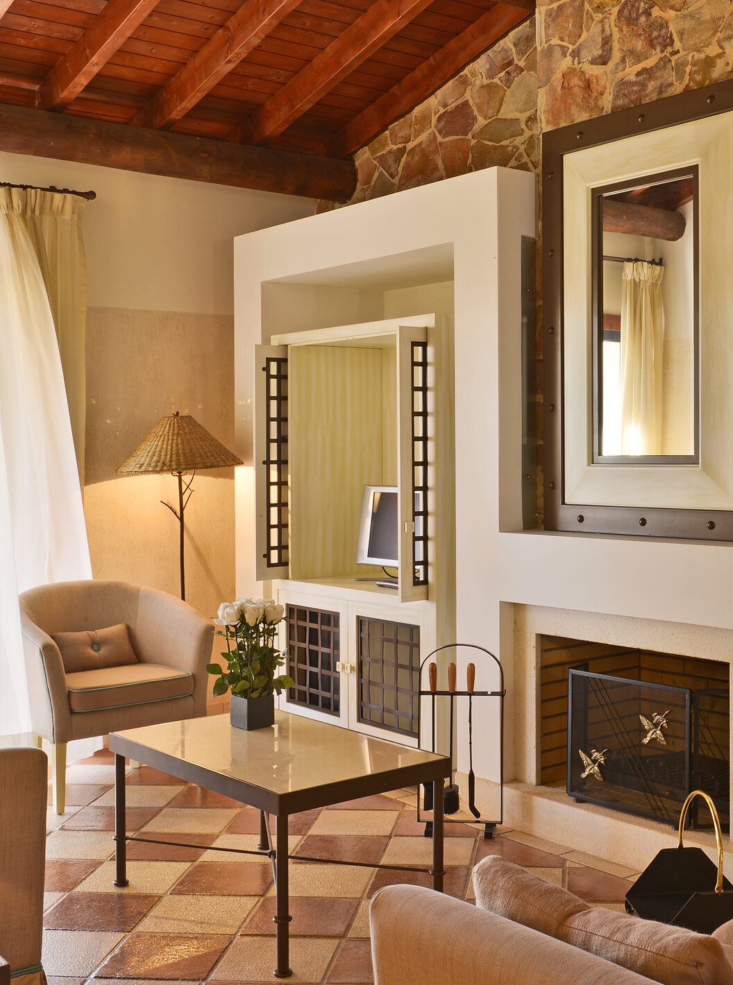 La Suite Vue Jardin Vila Sol du Pestana Vila Sol - Vilamoura avec salon, canapés, table basse, cheminée et fenêtre