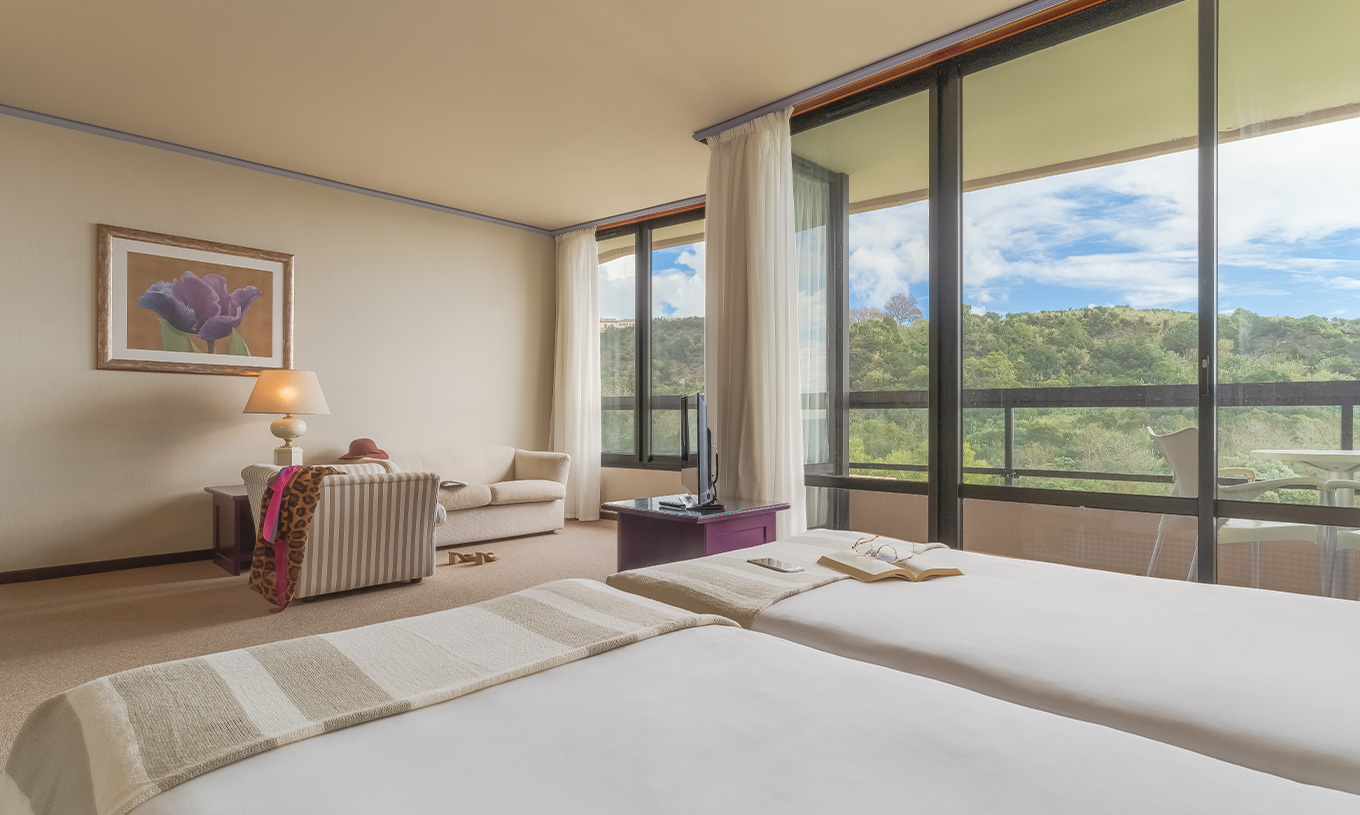 La Junior Suite Vista Jardim du Pestana Bahia Praia a une belle vue sur le paysage vert avec accès à la terrasse