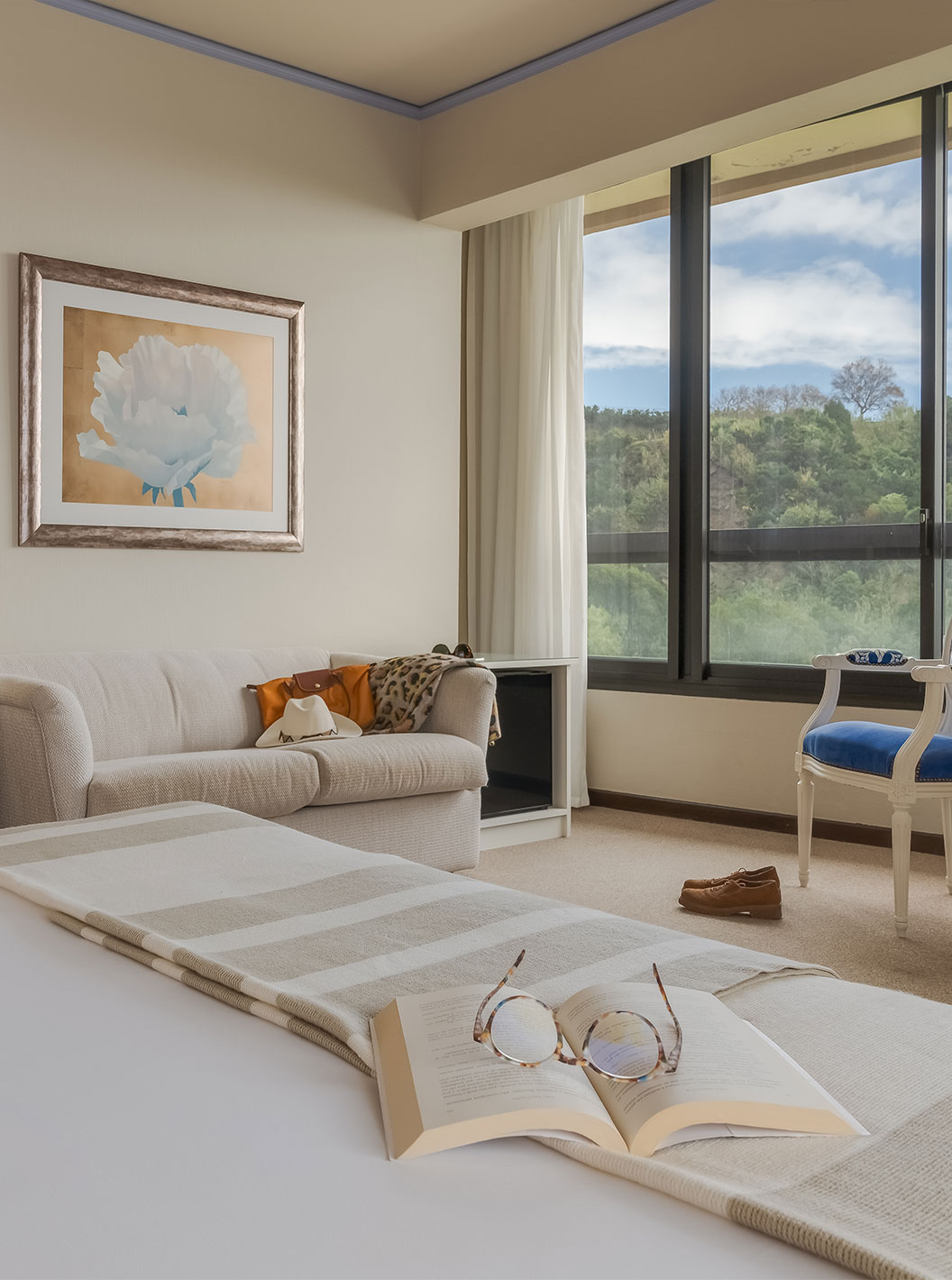 Le Standard Vista Mar du Pestana Bahia Praia a un bureau un canapé et une chaise près de la fenêtre avec vue sur le jardin