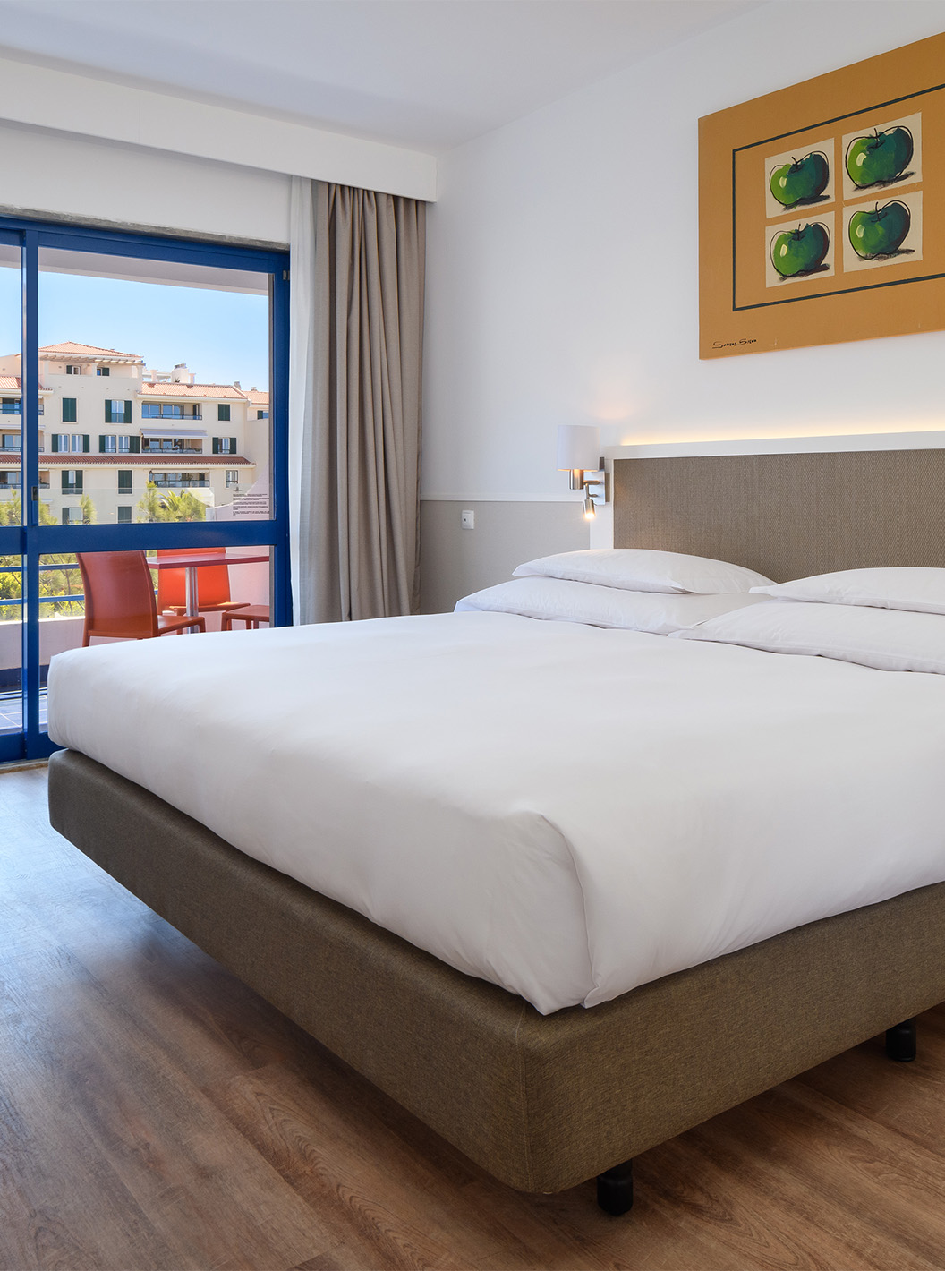 La Suite Deluxe du Pestana Cascais a un lit double, bureau et un tableau peint au mur
