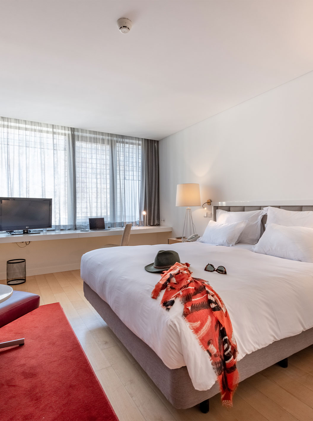 La Chambre Classique du Pestana Cidadela Cascais a un lit double, une télévision, un tapis rouge et une grande fenêtre