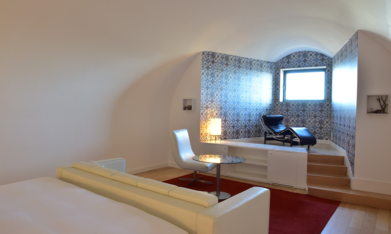 La Junior Suite Art District du Pestana Cidadela Cascais a une table basse avec une chaise et une chaise longue élégante