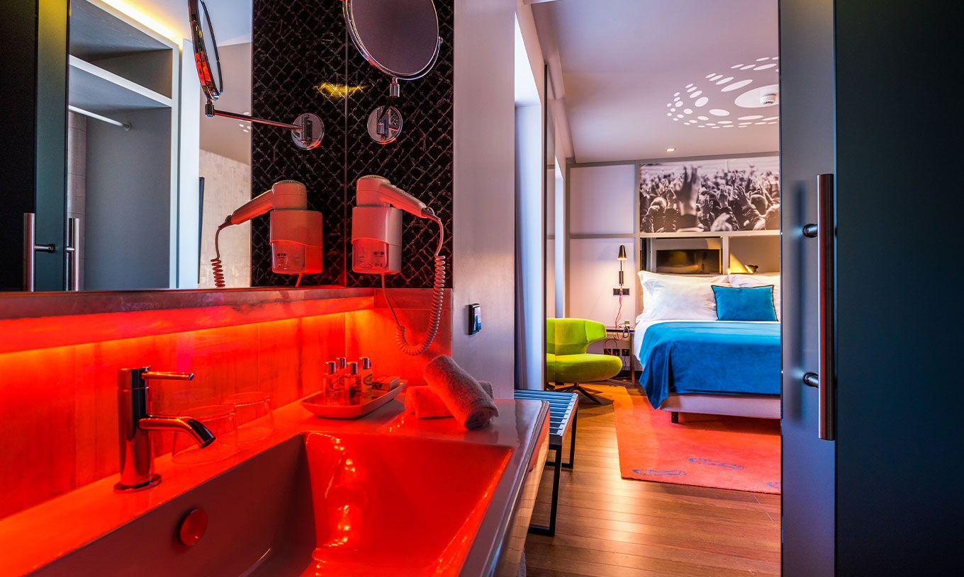 La chambre CR7 du Pestana CR7 Lisboa a un lit double, une salle de bain avec lavabo, miroir et sèche-cheveux