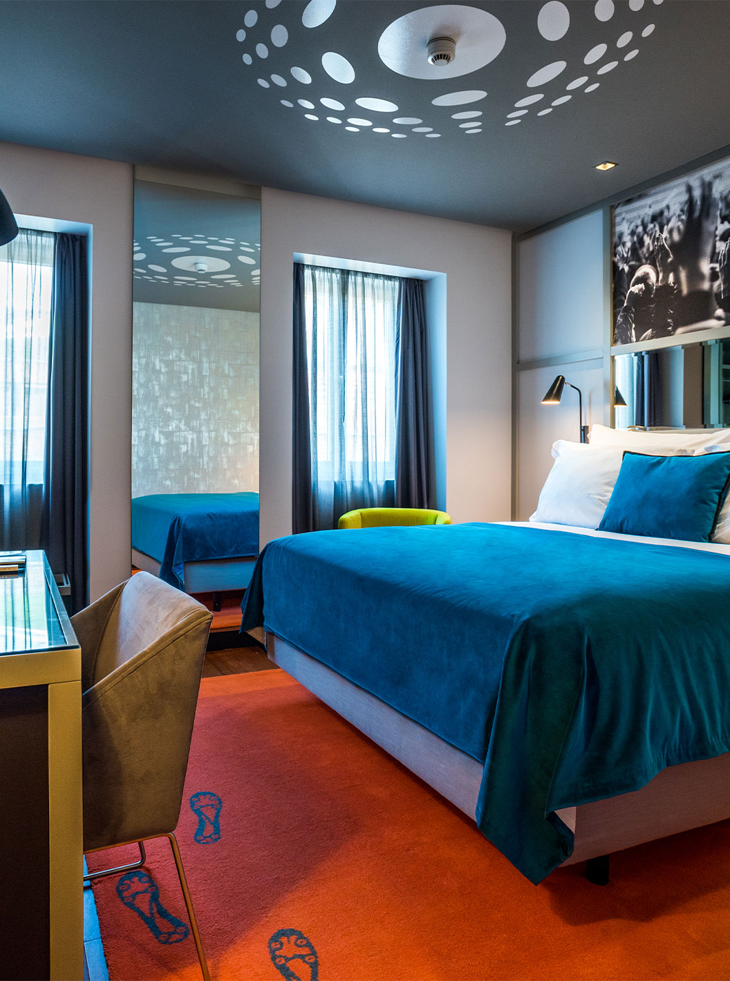 La chambre CR7 du Pestana CR7 Lisboa a un lit double, un miroir et un bureau moderne