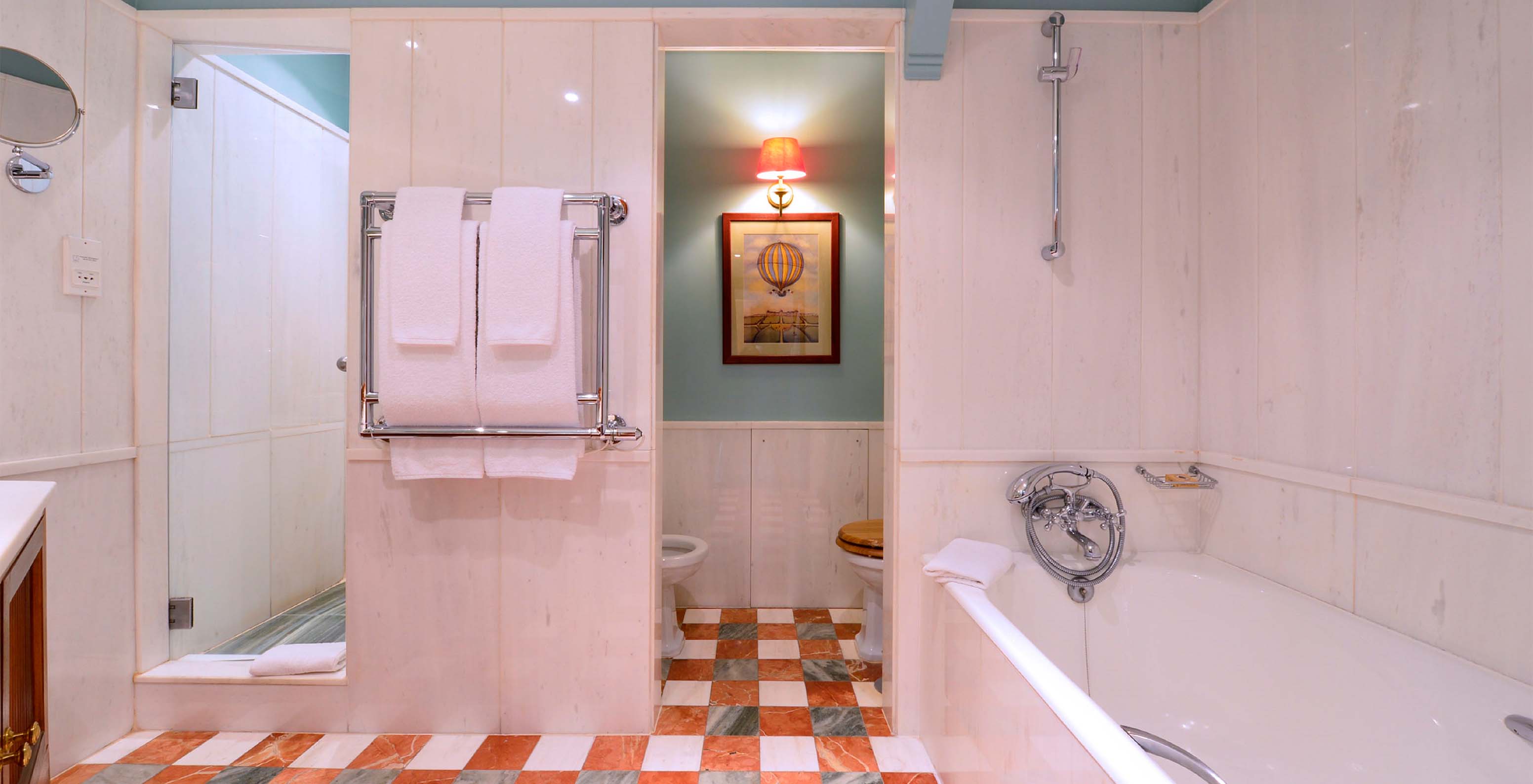 La Suite du Pestana Palace Lisbonne a une salle de bain en marbre blanc avec baignoire, douche, WC et serviettes
