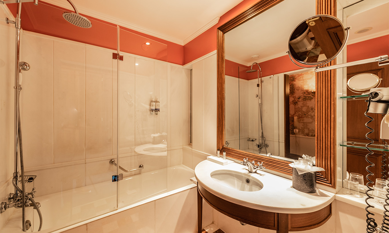 Le Premium Balcony du Pestana Palace Lisbonne a une salle de bain avec baignoire, lavabo avec miroir et miroir grossissant