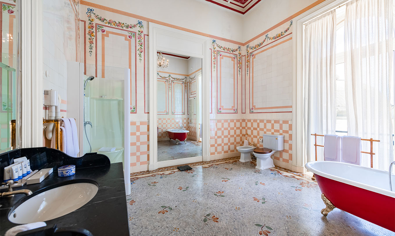 La Suite D. Amélia du Pestana Palace Lisbonne a une grande salle de bain avec carrelage, fenêtre, baignoire, douche et miroir