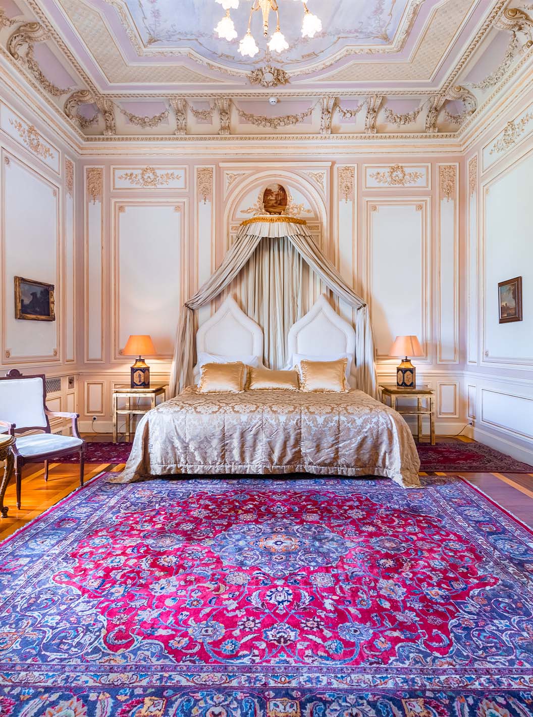 La Suite D. Carlos du Pestana Palace Lisbonne a une chambre luxueuse avec un lit double et un plafond orné de détails
