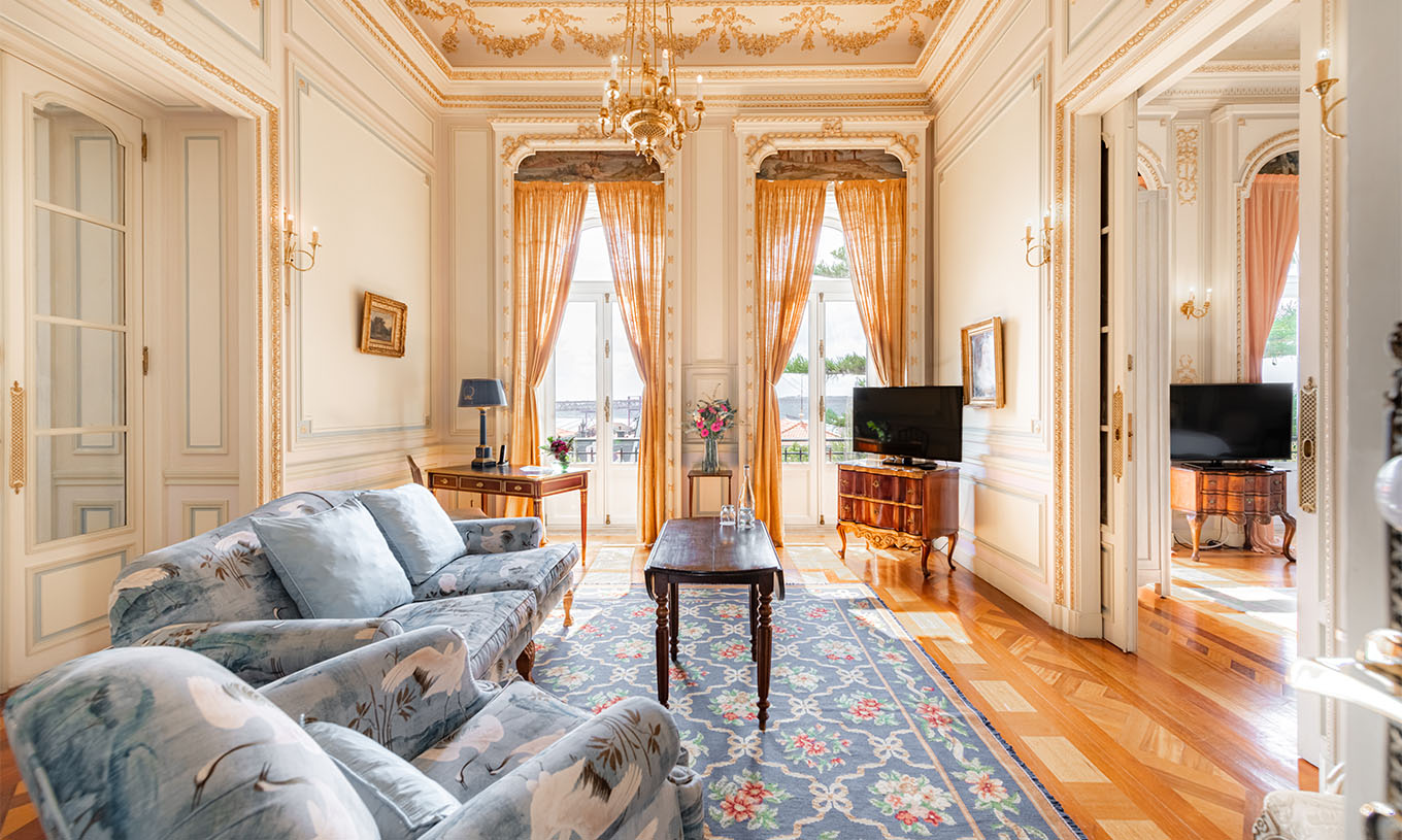 La Suite D. Manuel/ D. Luís Filipe du Pestana Palace Lisbonne a un salon luxueux avec canapé, télévision, fenêtre et tapis
