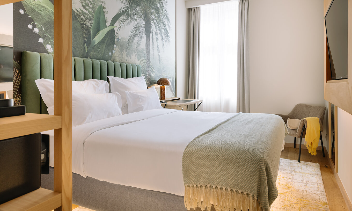 La Suite Familiale du Pestana Rua Augusta Lisboa a un lit double avec télévision en face et une fenêtre avec rideaux