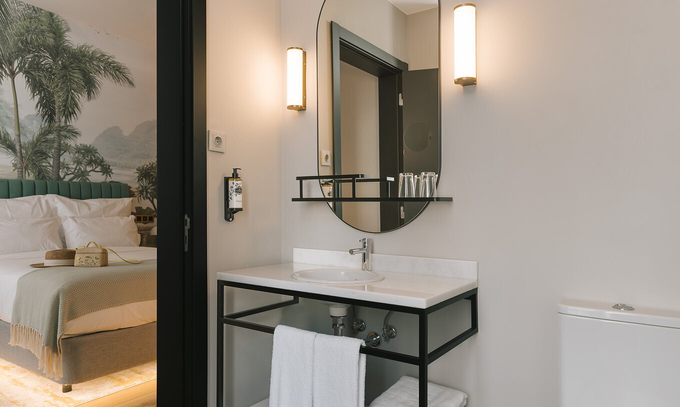 La chambre Supérieure du Pestana Rua Augusta Lisboa a une salle de bain avec lavabo en marbre blanc, miroir et serviettes