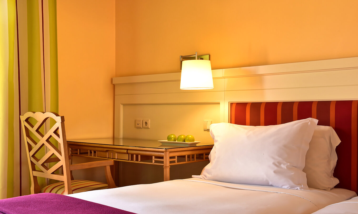 Le Duplo Clássico du Pestana Sintra Golf a un lit avec draps blancs et coussin, et un bureau avec une chaise