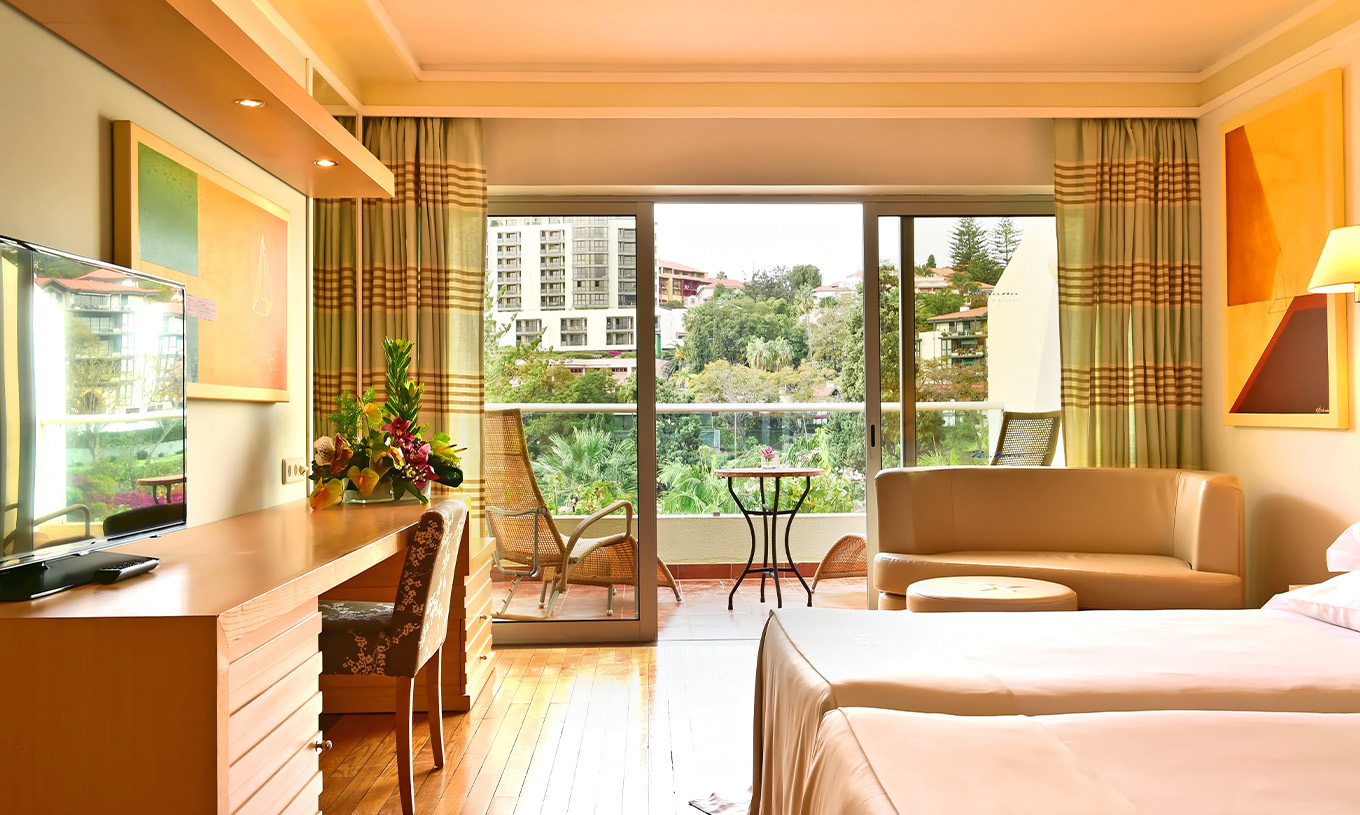 Le Double Classique Vue Piscine du Pestana Carlton Madeira a un lit double, un bureau et un balcon