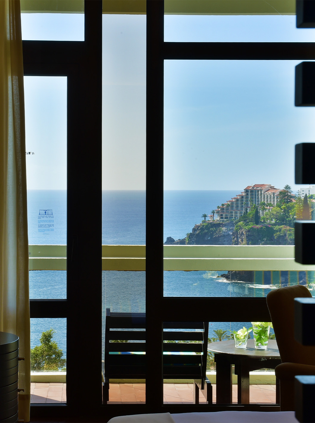 La Suite Vue Terre du Pestana Casino Park a une télévision et un balcon avec une table et vue sur la mer