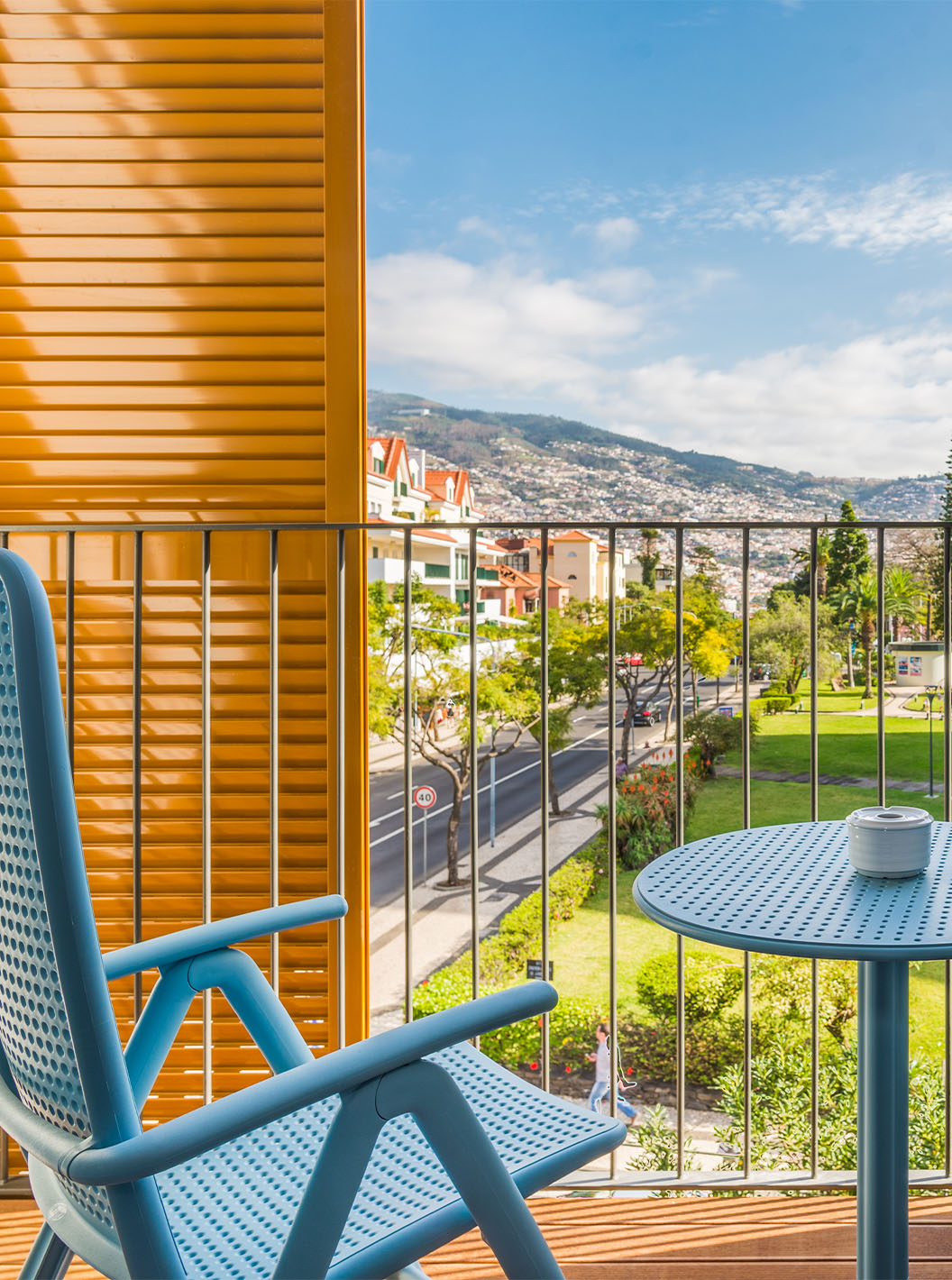 L'Appartement Deluxe du Pestana Casino Studios a un balcon avec vue sur la ville et une table avec des chaises bleues