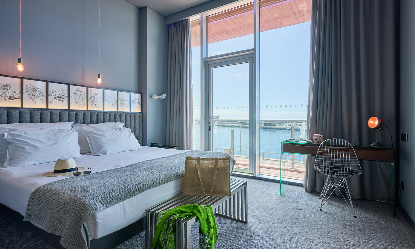 La Chambre CR Superior du Pestana CR7 Funchal a un lit double à côté du balcon, avec vue sur la mer