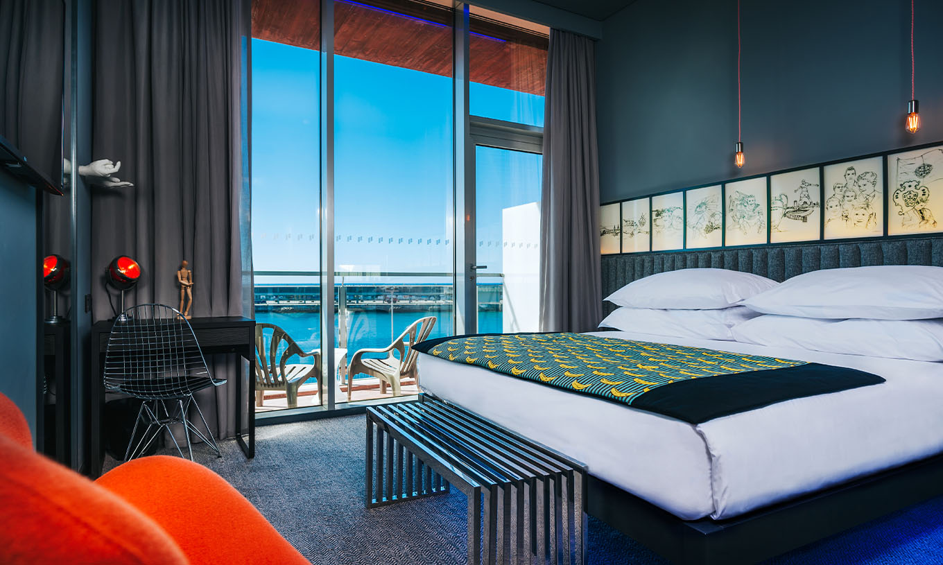 La Chambre CR Superior du Pestana CR7 Funchal a un balcon à côté du lit double, avec deux chaises et vue sur la mer