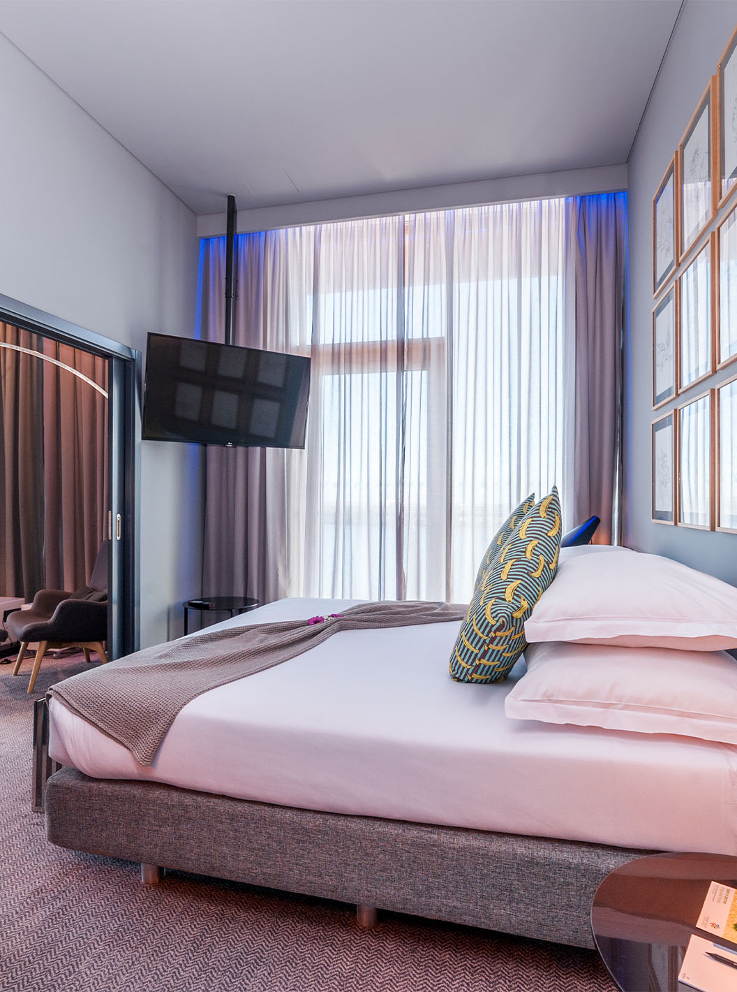 La CR7 Suite du Pestana CR7 Funchal a une chambre avec un lit double, une télévision fixée au mur et une fenêtre