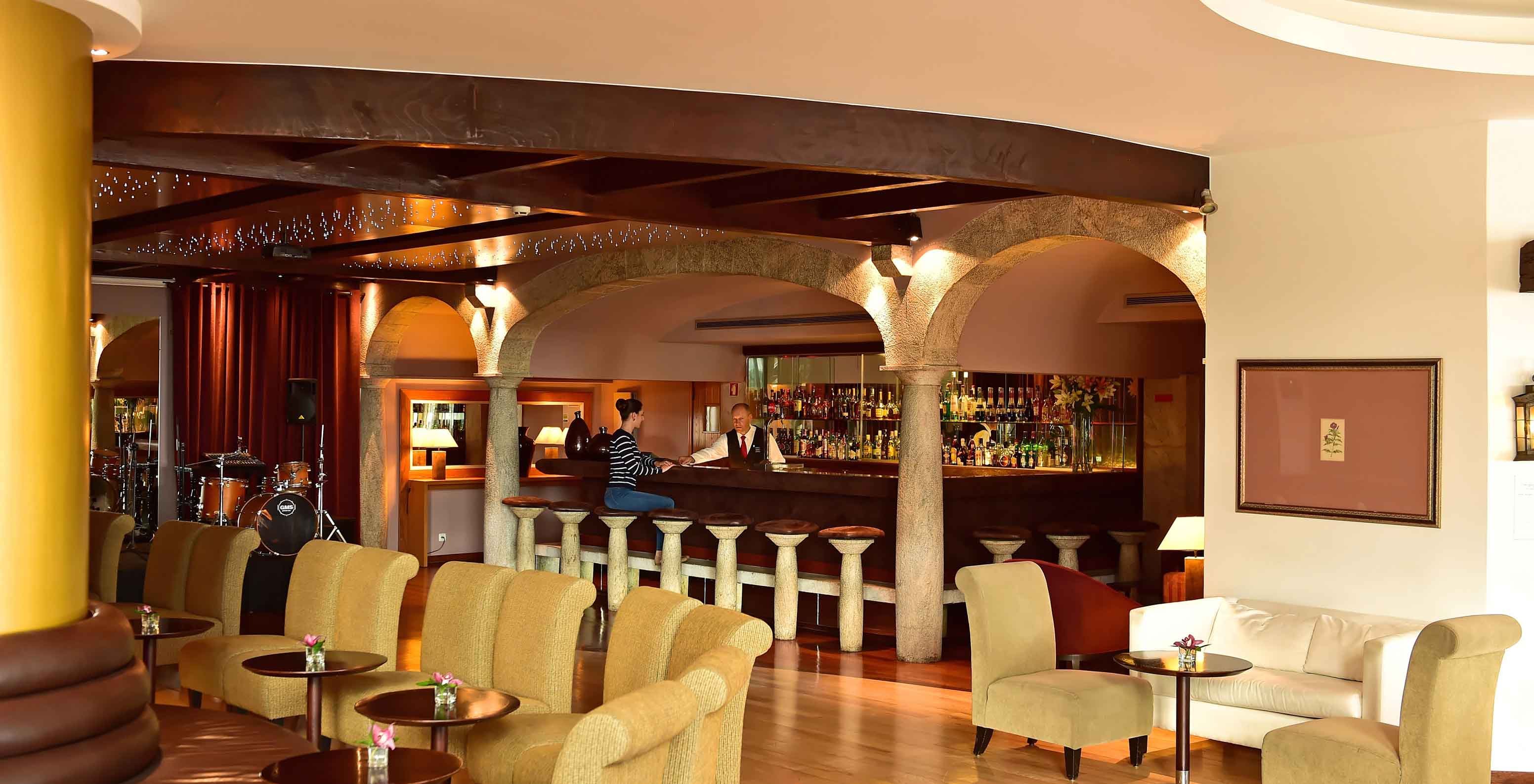 Le bar Taverna, à l'Hôtel au Centre de Funchal, à Madère, a des tabourets hauts, des fauteuils et des canapés