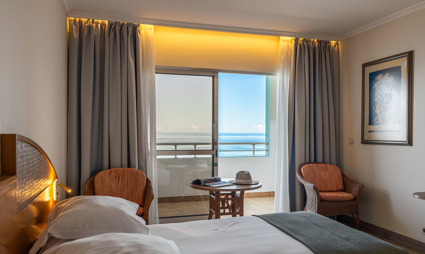 Le Classic Sea View du Pestana Ocean Bay All Inclusive dispose d'un lit double, de deux chaises et d'un balcon