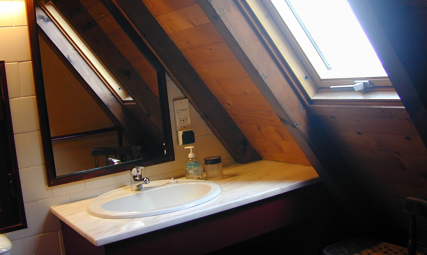 Les Villas Duplex du Pestana Quinta do Arco ont salle de bain avec lavabo et fenêtre inclinée, miroir et plafond bois