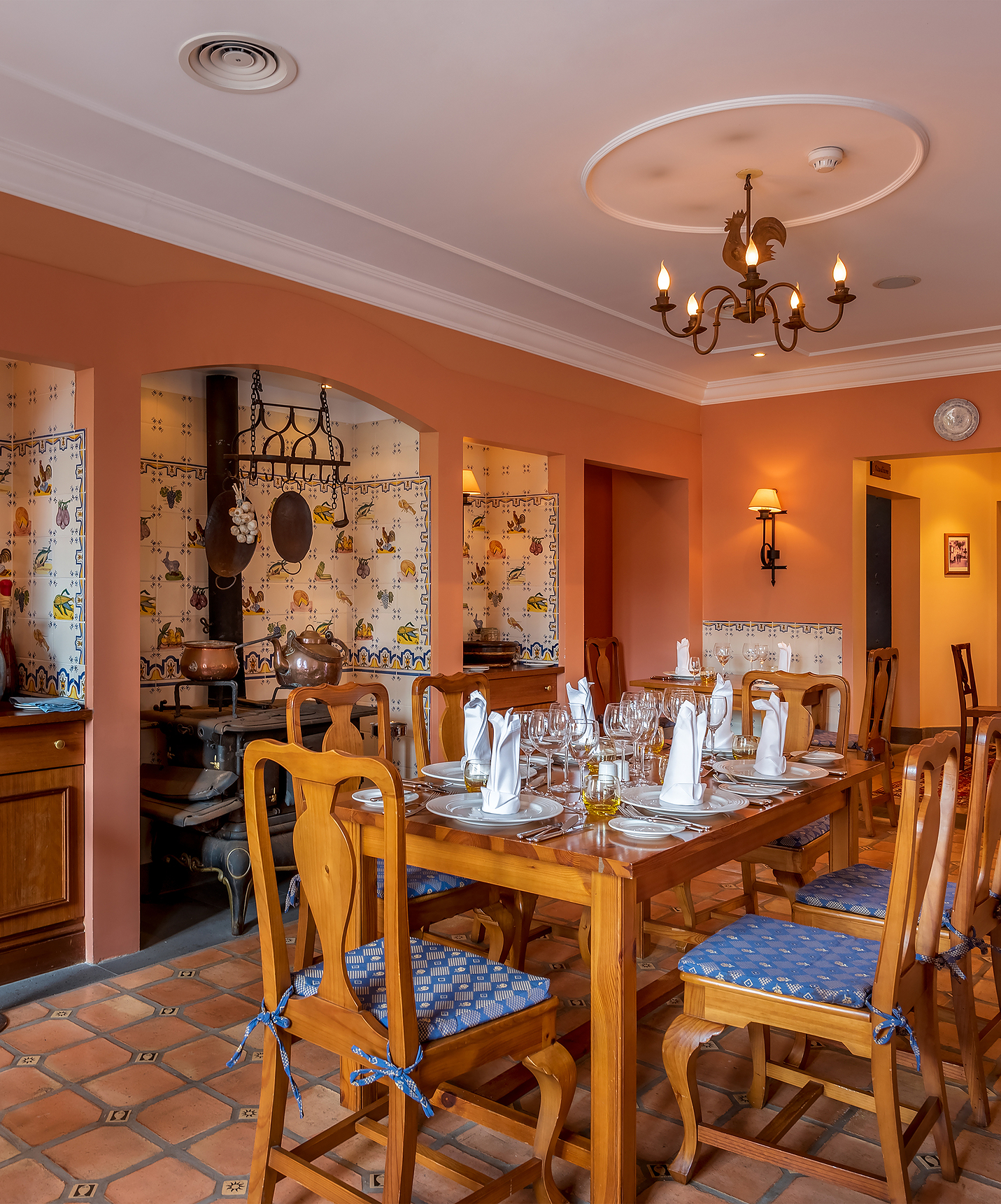 Restaurant avec décoration ancienne imitant une cuisine, avec tables et chaises en bois au Quinta Perestrello