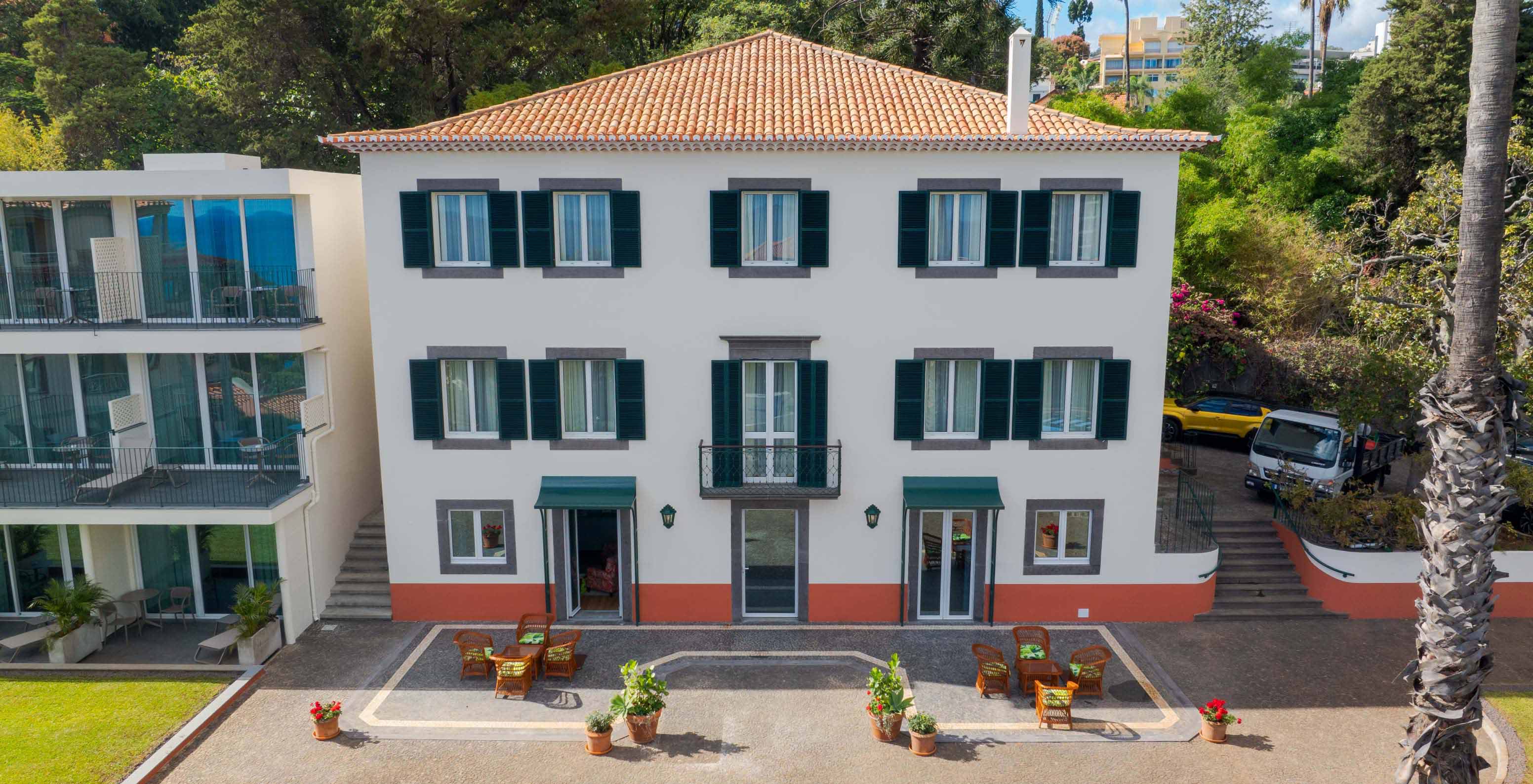 Façade du bâtiment du Pestana Quinta Perestrello, un Hôtel de Charme à Madère, entouré d'arbres