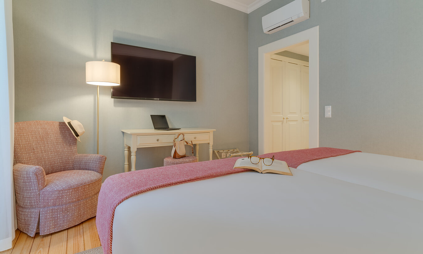 La chambre Classique Vue Intérieure du Pestana Quinta Perestrello a une télévision devant le lit, un fauteuil et un meuble