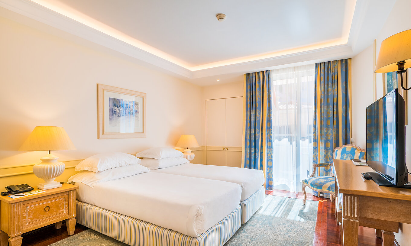 La chambre Deluxe avec Balcon Vue Mer du Pestana Royal All Inclusive a deux lits individuels et table de nuit