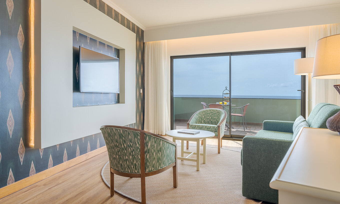 La Suite Supérieure Vue Mer du Pestana Vila Lido Madeira a un salon, avec canapé, fauteuils et télévision