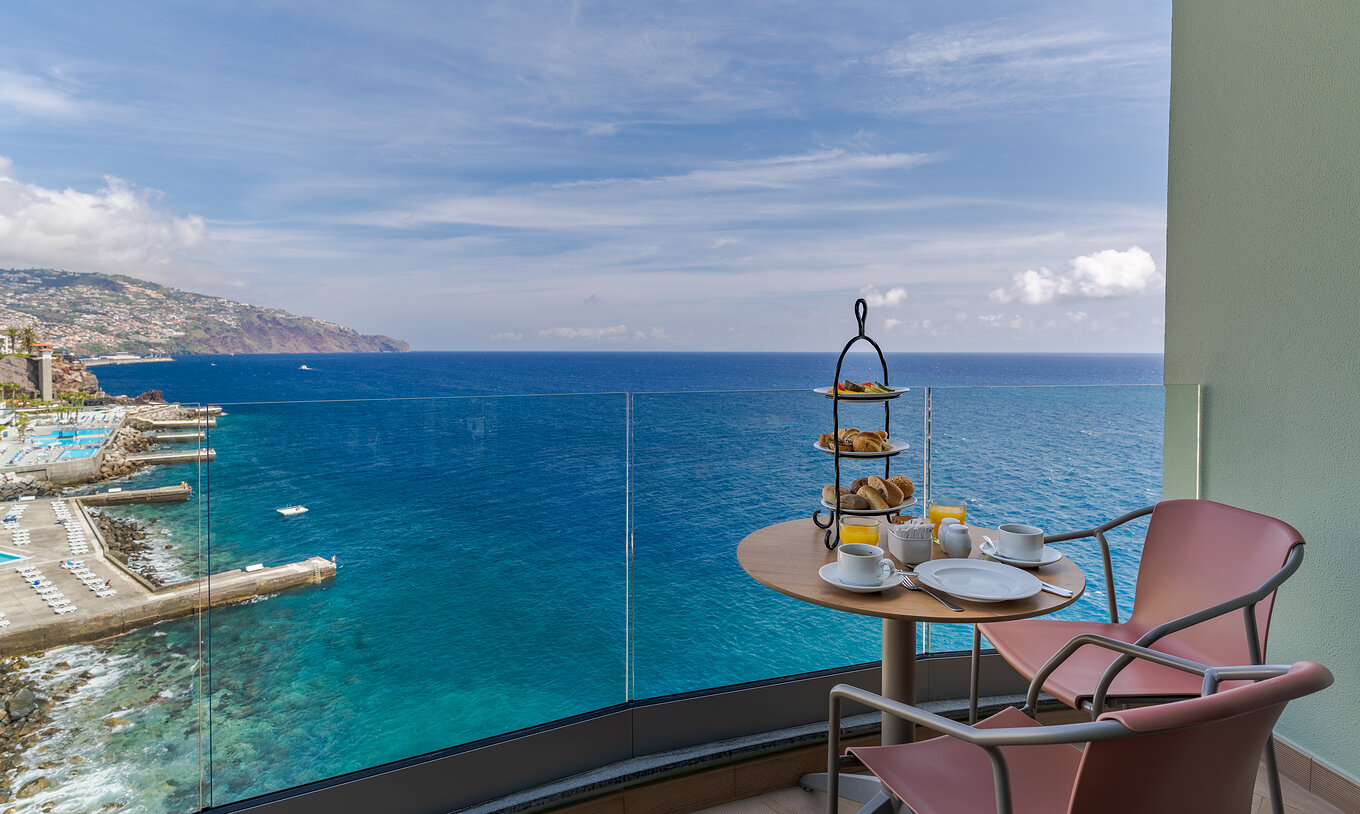 Le Supérieur Vue Mer du Pestana Vila Lido Madeira a un balcon avec une table avec snacks et vue sur la mer