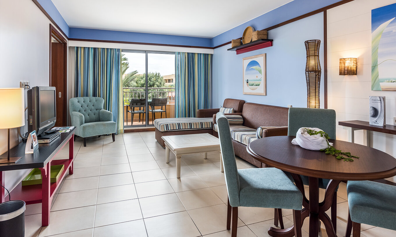 La Suite Appartement T2 du Pestana Porto Santo All Inclusive a un salon avec deux canapés, télévision et accès au balcon