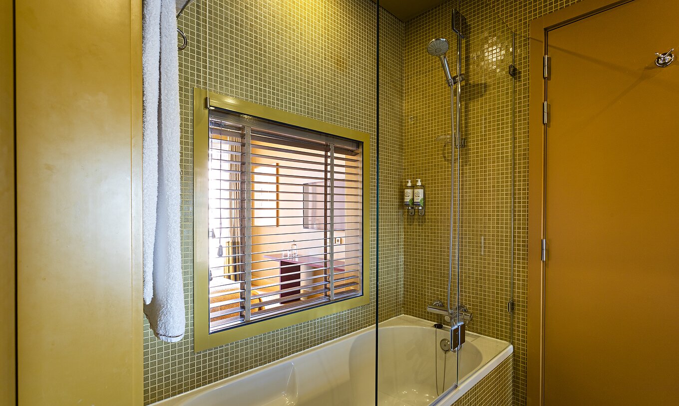 La Suite Balcony comprend une salle de bain avec baignoire et fenêtre sur la chambre