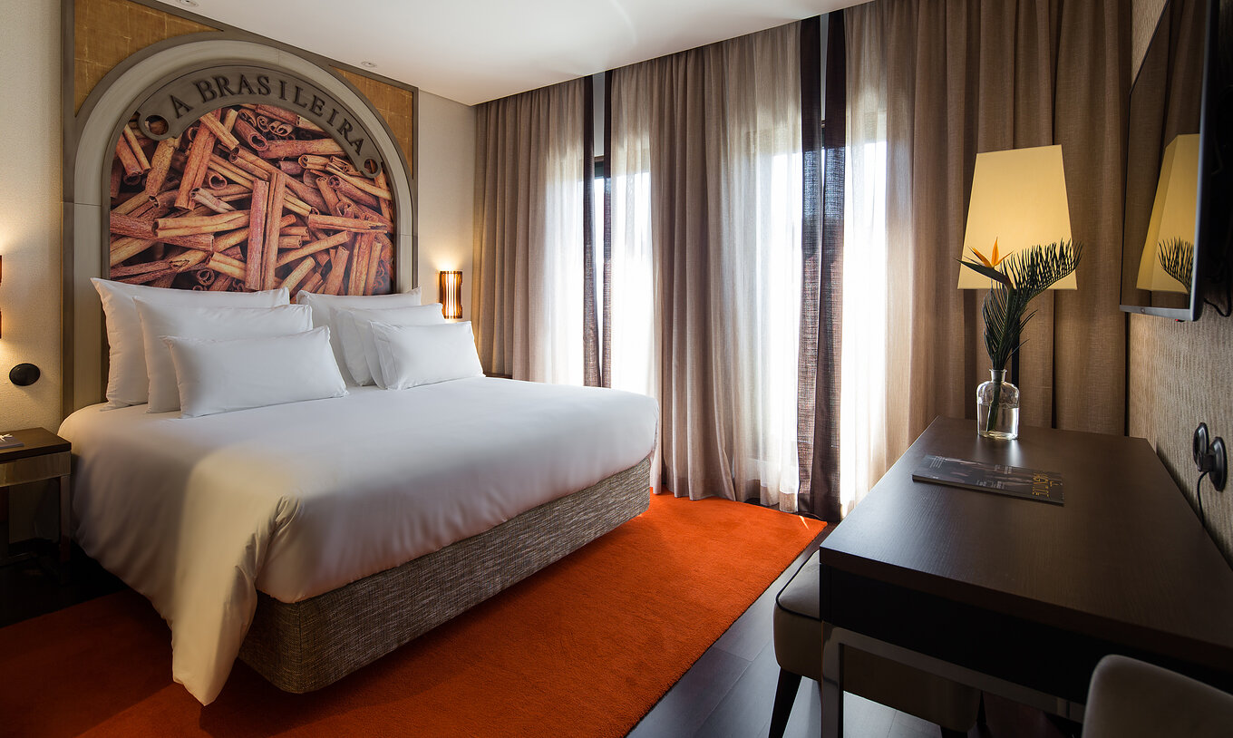 Le Deluxe Exécutif Grand View du Pestana Porto - A Brasileira a un lit king size avec une fresque thématique sur la cannelle