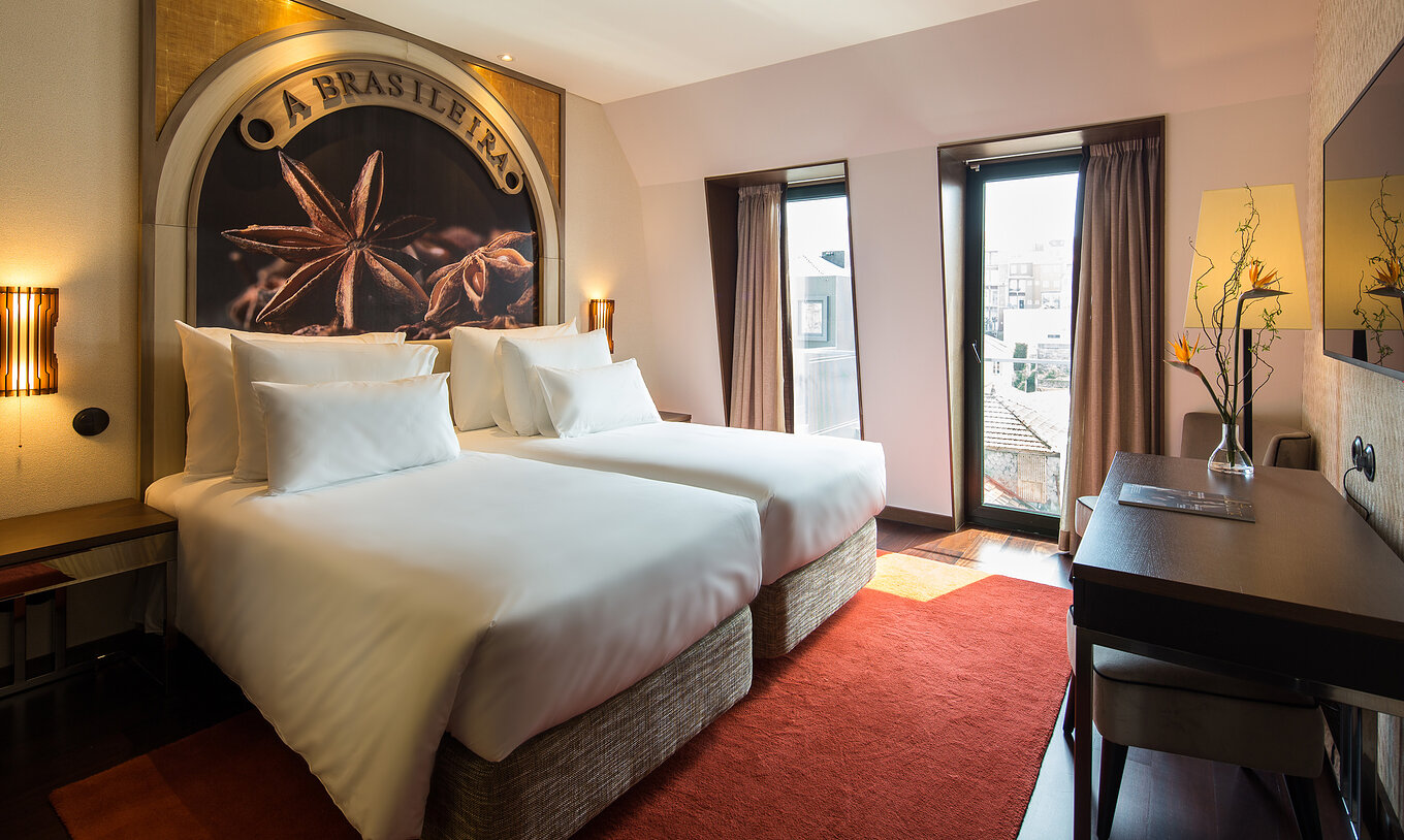 Chambre Premium Origin du Pestana Porto - A Brasileira avec deux lits, bureau en bois et grandes fenêtres