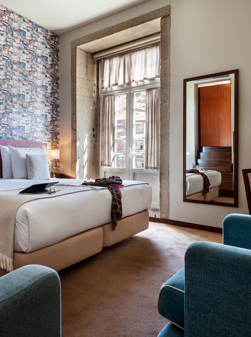 Le Plaza du Pestana Vintage Porto a un lit double, un papier peint avec photographies de voyages, et un fauteuil