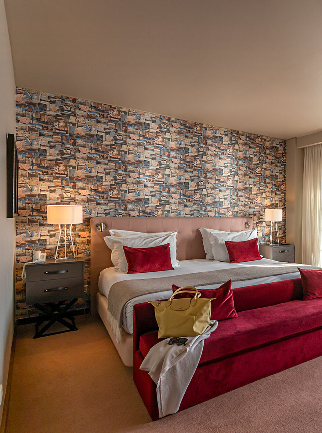 La Suite Grand View du Pestana Vintage Porto dispose d'un lit double, d'un canapé rouge et de fenêtres avec vue sur Porto