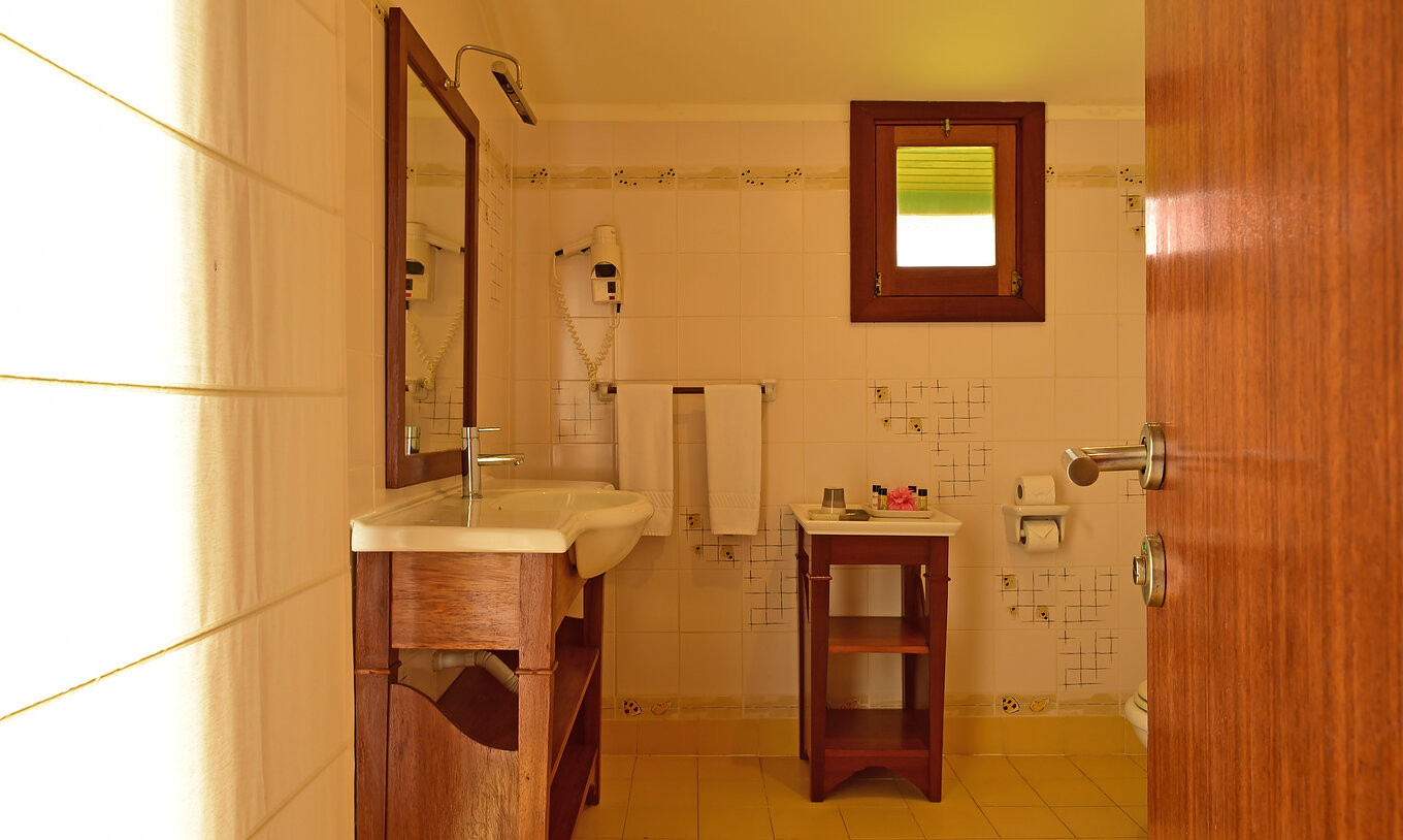 Le Double Supérieur du Pestana Equador Ilheu das Rolas a une salle de bain avec lavabo, miroir, sèche-cheveux et fenêtre