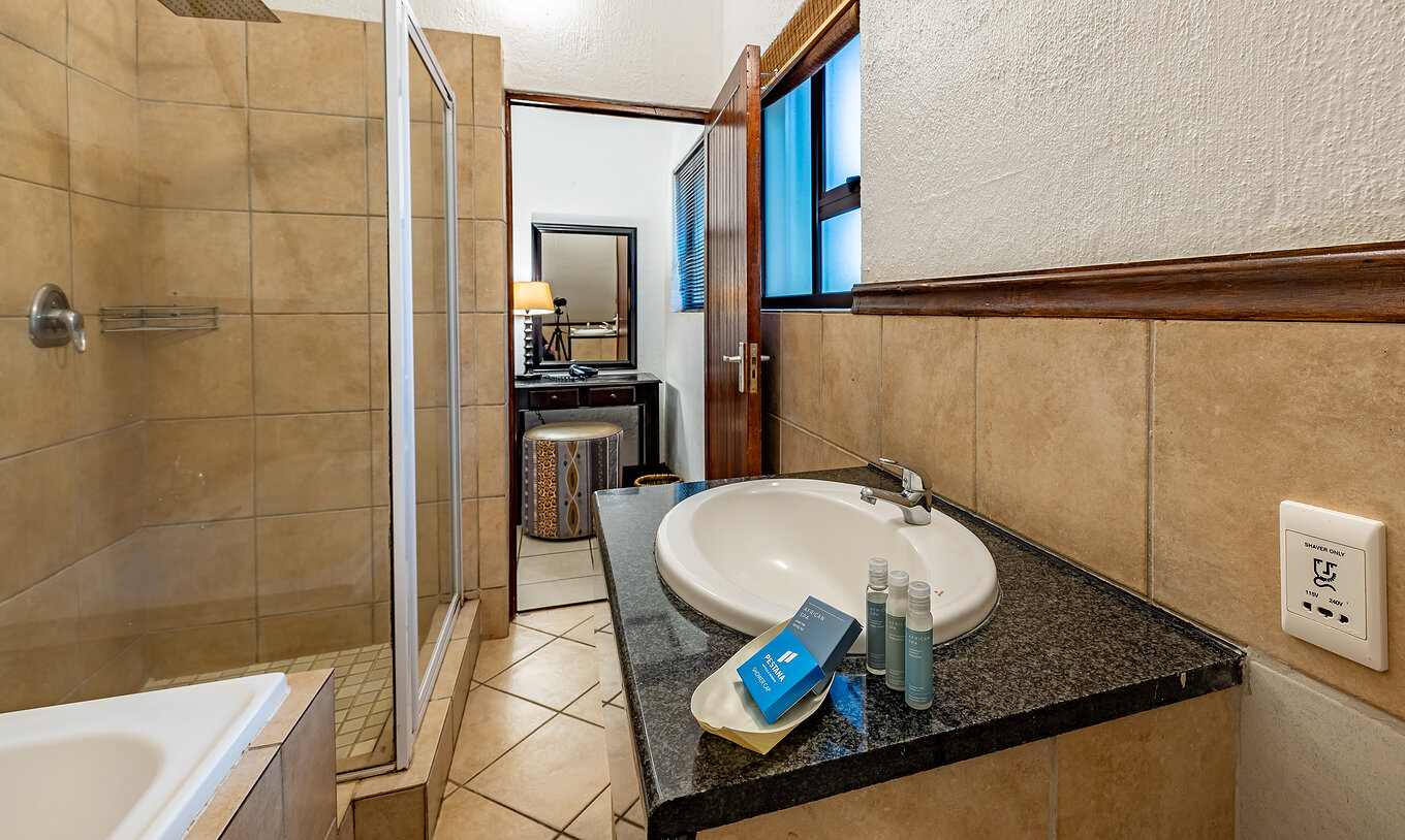 La Chambre Familiale du Pestana Kruger Lodge a une salle de bain avec baignoire douche lavabo et amenities