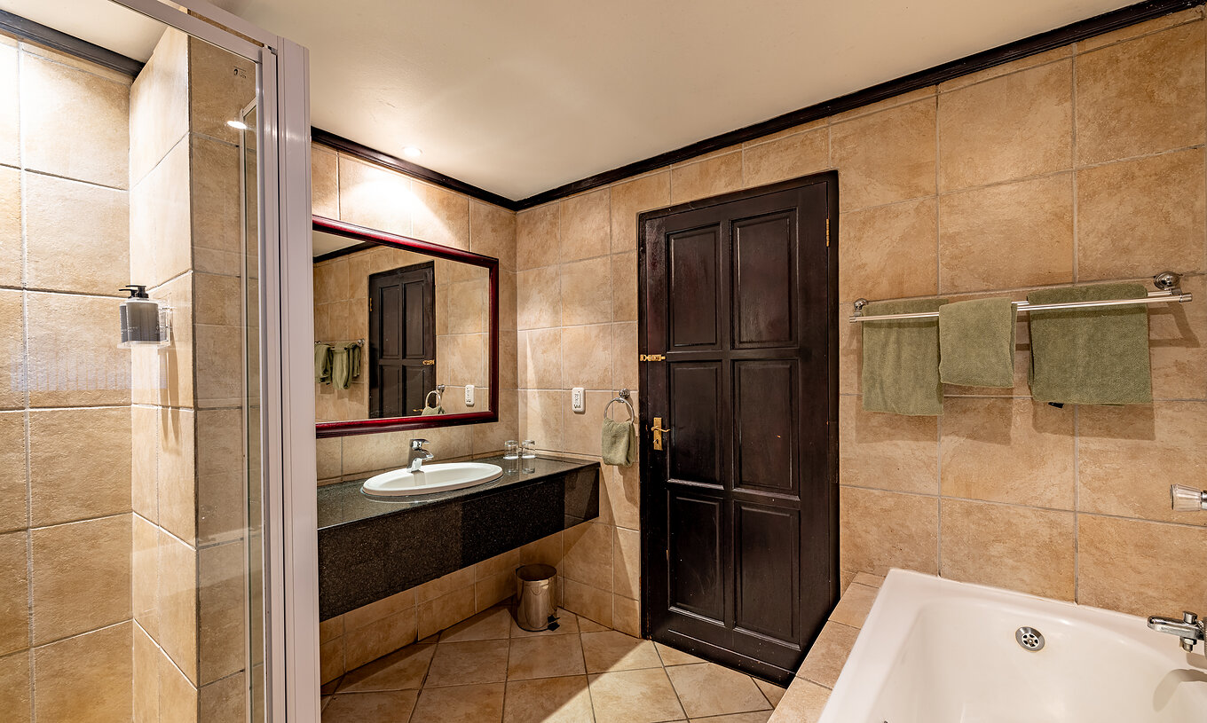La Premium Room du Pestana Kruger Lodge a une salle de bain avec baignoire douche et lavabo avec miroir