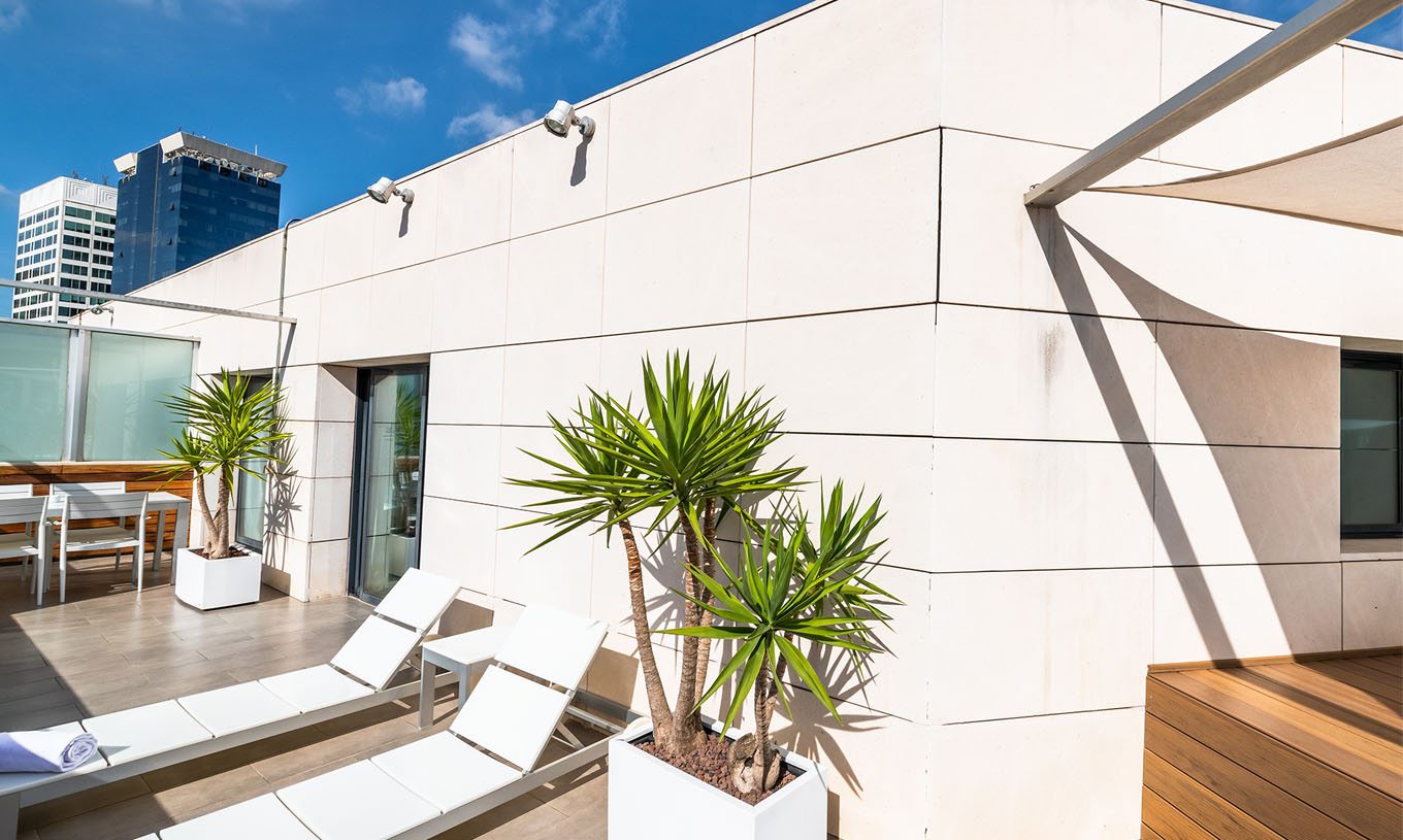 La Junior Suite du Pestana Arena Barcelona a une terrasse sur le toit avec chaises longues pour se détendre.